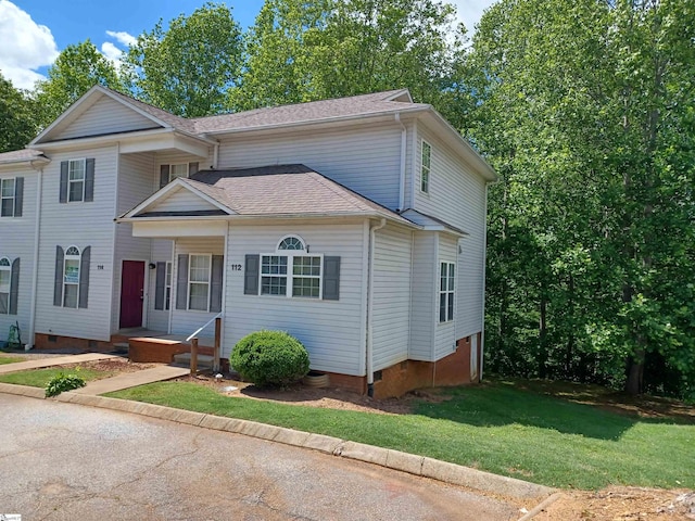 traditional home featuring crawl space, a front lawn, and a shingled roof