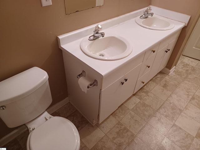 bathroom with toilet and double vanity