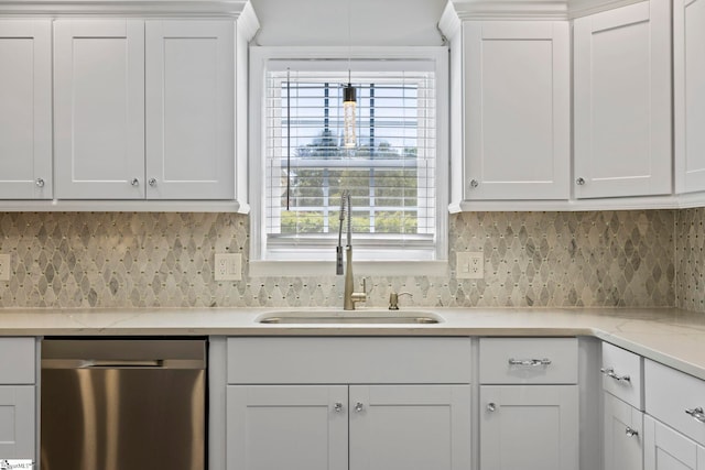 kitchen featuring stainless steel dishwasher, white cabinetry, decorative backsplash, and a sink