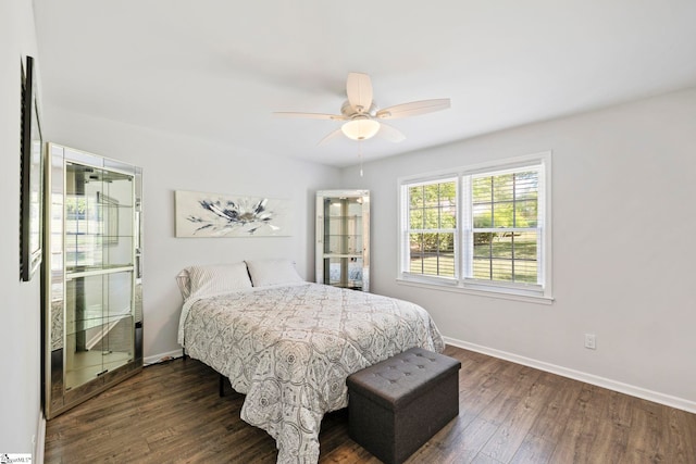 bedroom with dark wood-type flooring, baseboards, and ceiling fan