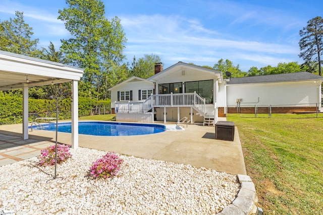 outdoor pool with fence, a sunroom, stairway, a patio, and a yard