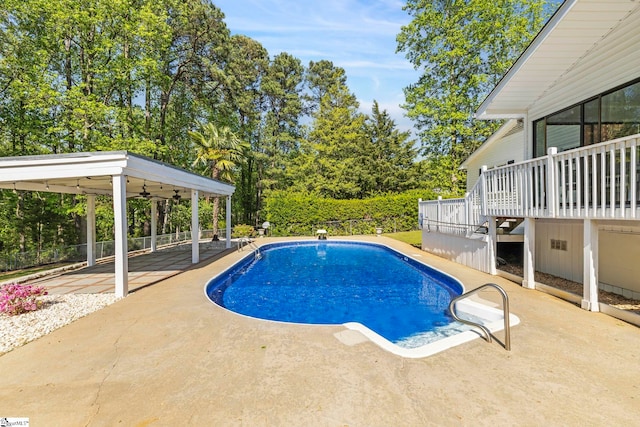 view of swimming pool featuring a ceiling fan, a deck, a patio area, fence, and a fenced in pool