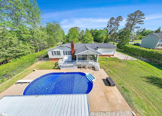 outdoor pool featuring fence, a deck, stairway, a patio area, and a lawn
