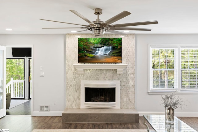 unfurnished living room with a ceiling fan, visible vents, wood finished floors, baseboards, and recessed lighting