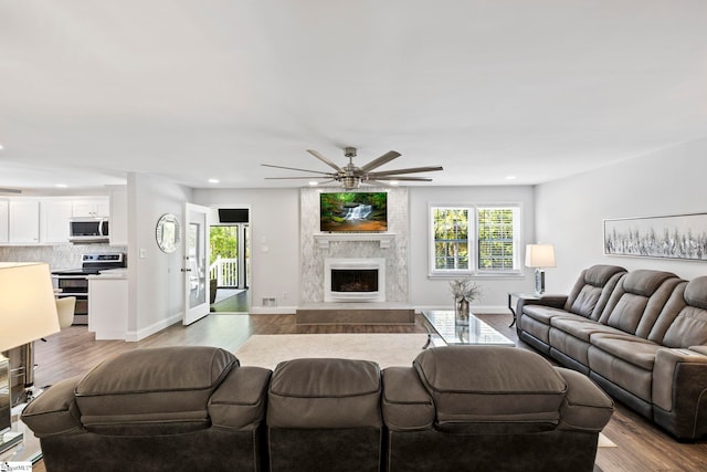 living room featuring baseboards, ceiling fan, recessed lighting, and wood finished floors