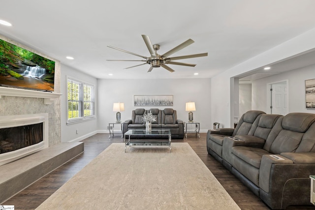 living area featuring ceiling fan, a fireplace, dark wood finished floors, baseboards, and recessed lighting