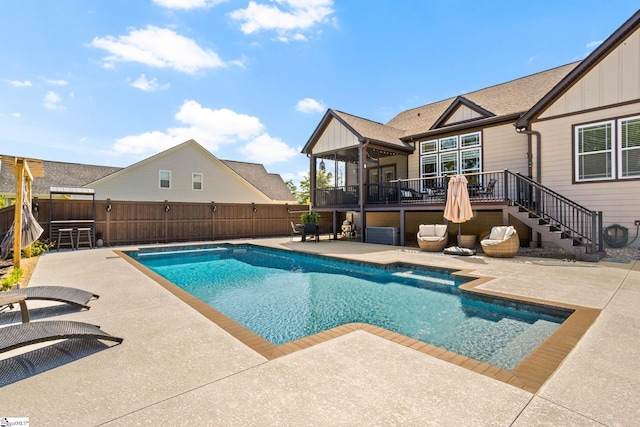 view of swimming pool featuring a patio, stairs, a fenced backyard, and a deck