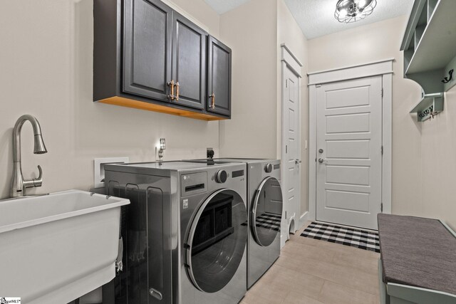 clothes washing area with a sink, light tile patterned flooring, cabinet space, and washing machine and clothes dryer