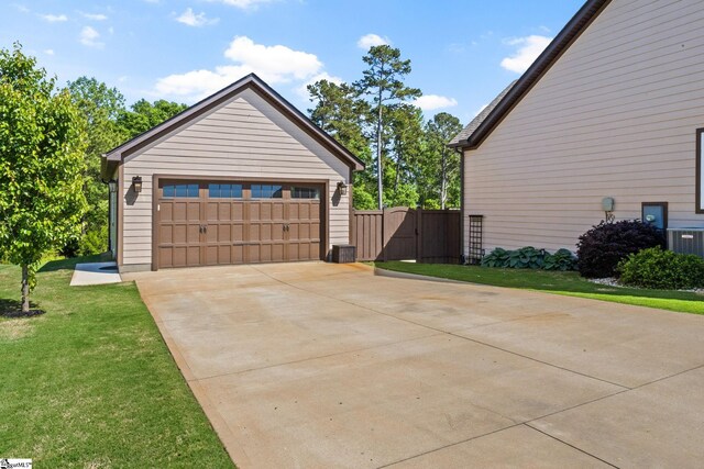 view of property exterior with a lawn, a gate, central AC, and a detached garage