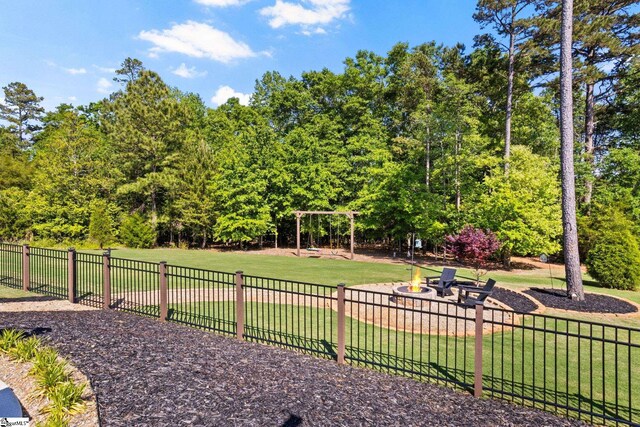 view of property's community with a lawn and fence