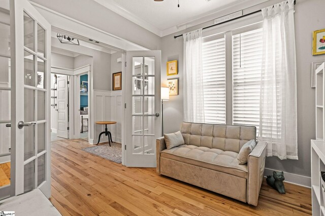 living area with ceiling fan, ornamental molding, french doors, and wood finished floors