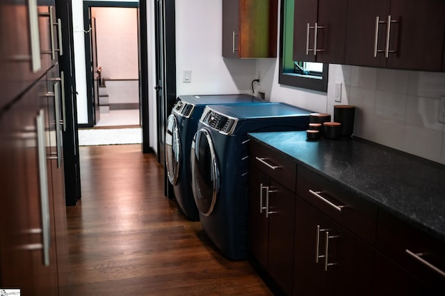 clothes washing area with dark wood finished floors, cabinet space, and washer and dryer
