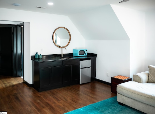 sitting room with visible vents, baseboards, dark wood-style flooring, and lofted ceiling