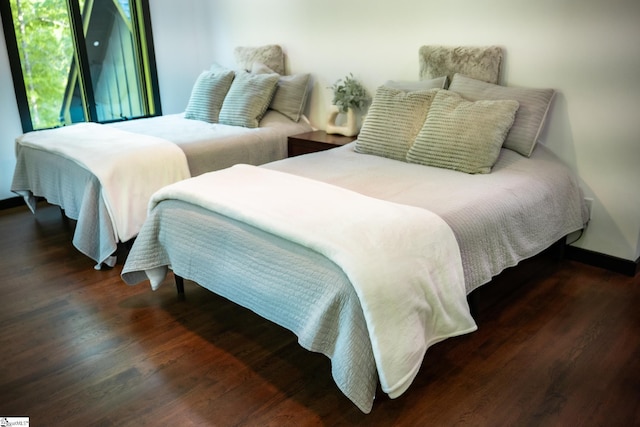 bedroom with baseboards and wood finished floors