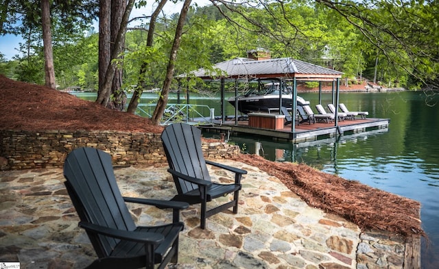 view of dock featuring a water view, a wooded view, and boat lift