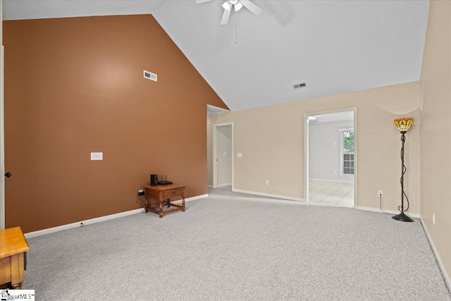 unfurnished living room with light colored carpet, ceiling fan, visible vents, and high vaulted ceiling