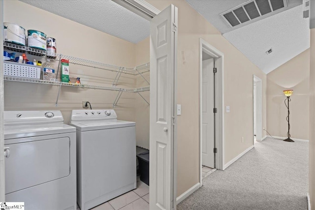 washroom featuring visible vents, laundry area, washing machine and dryer, baseboards, and a textured ceiling