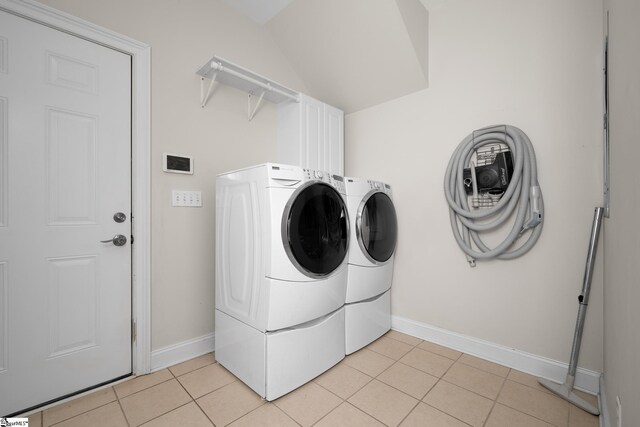 washroom with baseboards, cabinet space, light tile patterned flooring, and washing machine and clothes dryer