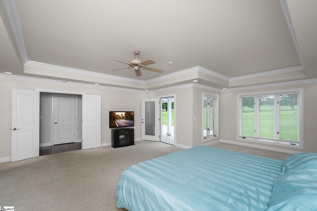 carpeted bedroom featuring crown molding, a tray ceiling, and access to exterior