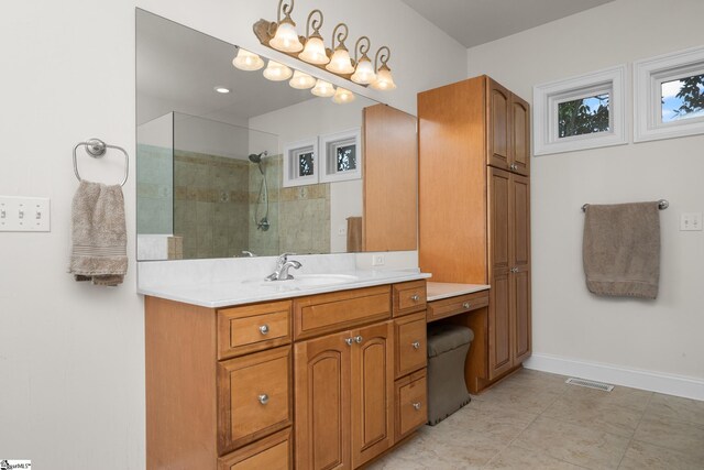 bathroom featuring visible vents, tile patterned flooring, walk in shower, vanity, and baseboards