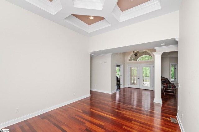 spare room featuring visible vents, ornamental molding, wood finished floors, a high ceiling, and french doors