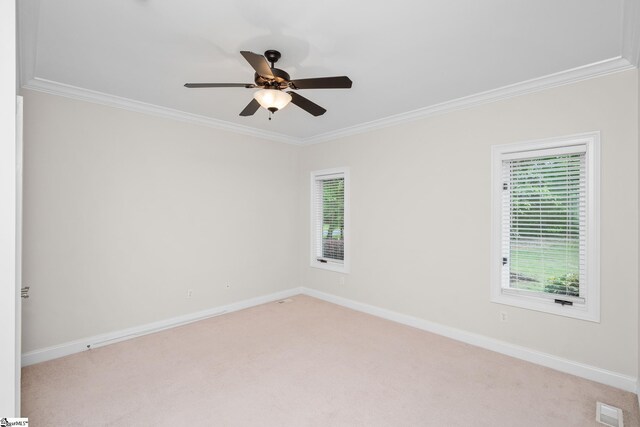 unfurnished room with baseboards, ornamental molding, light carpet, and plenty of natural light