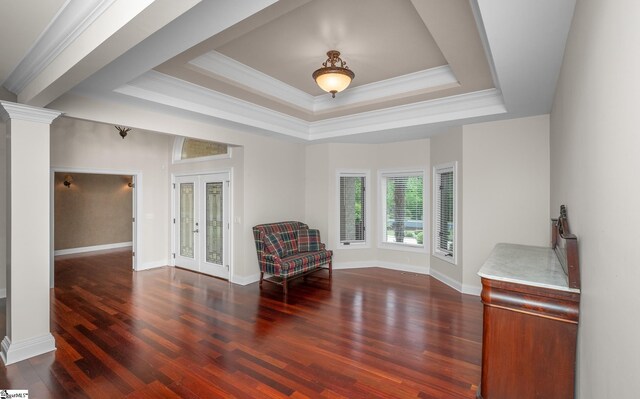 sitting room with french doors, a tray ceiling, ornamental molding, and wood finished floors