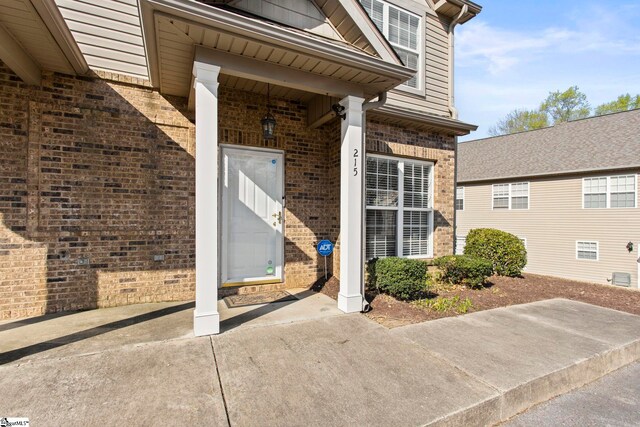 view of exterior entry with brick siding
