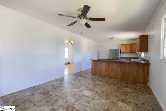2403 Dobbins Bridge Rd, Anderson, SC 29626 - kitchen featuring dark countertops, brown cabinets, a sink, freestanding refrigerator, and a peninsula