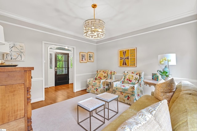 living room featuring crown molding, baseboards, wood finished floors, and a chandelier