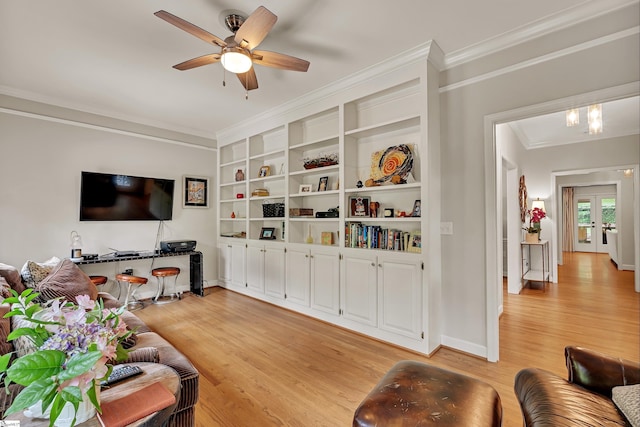living room featuring ceiling fan, built in features, baseboards, light wood finished floors, and ornamental molding