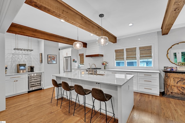 kitchen featuring beverage cooler, beamed ceiling, high end refrigerator, and tasteful backsplash