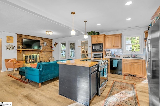 207 Tollgate Rd, Simpsonville, SC 29681 - kitchen featuring light brown cabinets, light wood-style floors, open floor plan, a sink, and black appliances