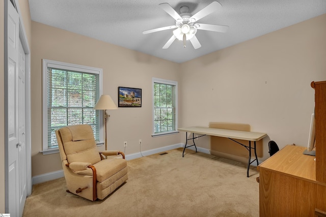 home office featuring baseboards, light carpet, a ceiling fan, and visible vents