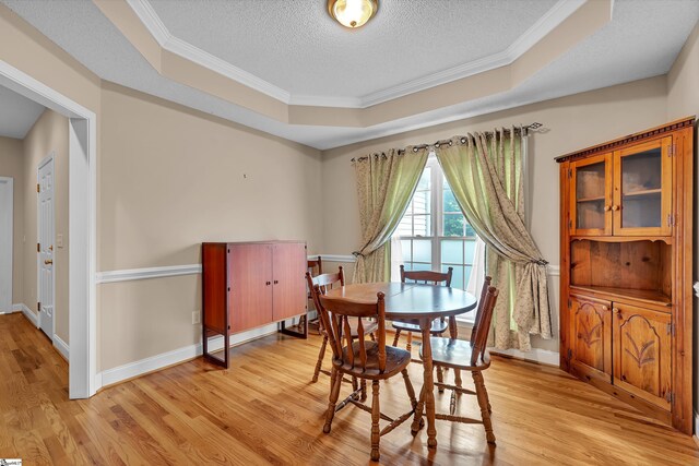 201 Cedar Creek Ln, Seneca, SC 29678 - dining room featuring ornamental molding, baseboards, a textured ceiling, a tray ceiling, and light wood-style flooring