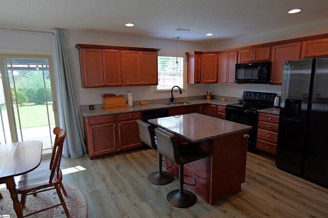 502 E Heatherstone Ln, Roebuck, SC 29376 - kitchen featuring light wood-style floors, a sink, stone counters, and black appliances