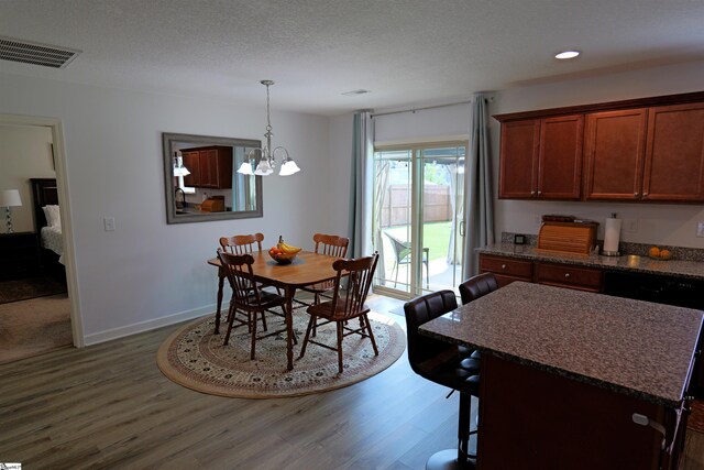 502 E Heatherstone Ln, Roebuck, SC 29376 - dining space featuring visible vents, a textured ceiling, wood finished floors, and a chandelier