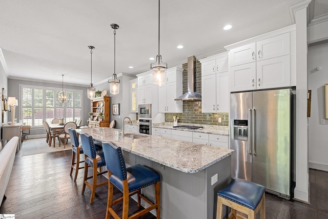 kitchen with wall chimney range hood, appliances with stainless steel finishes, white cabinets, and dark wood-type flooring
