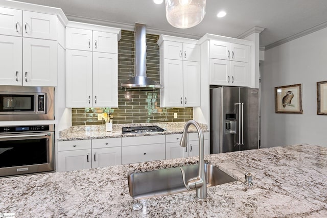 kitchen featuring crown molding, a sink, white cabinets, stainless steel appliances, and wall chimney exhaust hood