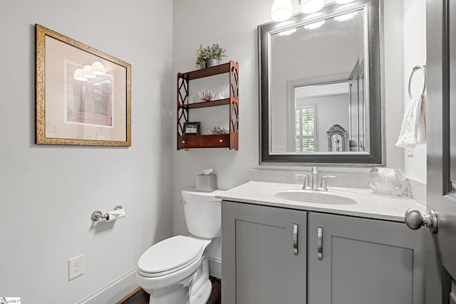 half bathroom featuring vanity and toilet