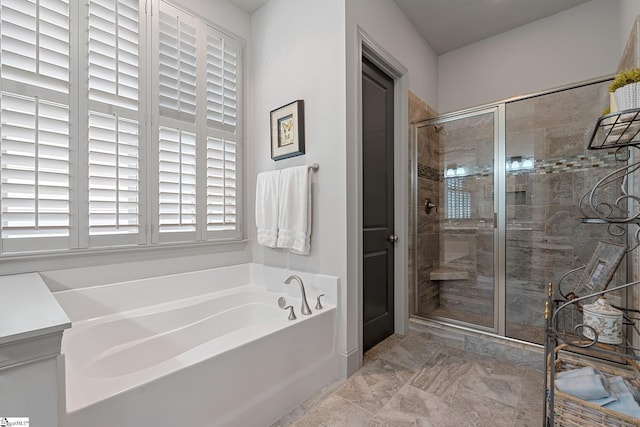 bathroom with a stall shower, marble finish floor, and a bath