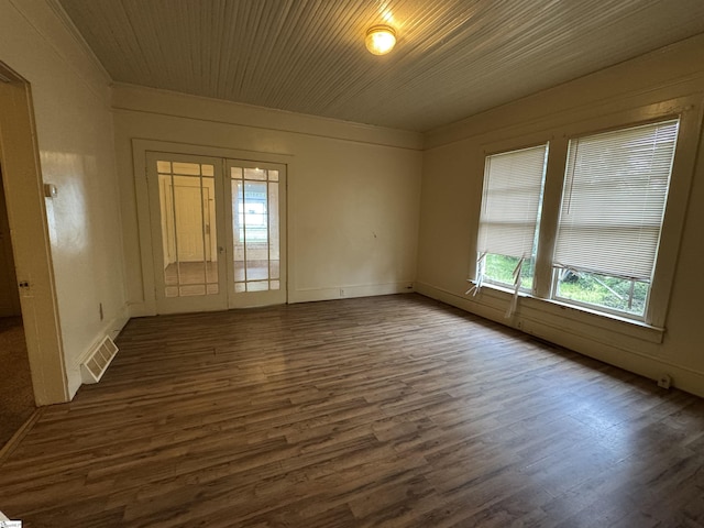 spare room with dark wood-type flooring, baseboards, and visible vents