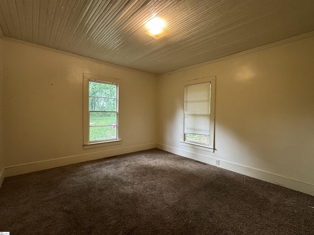 carpeted spare room featuring crown molding and baseboards
