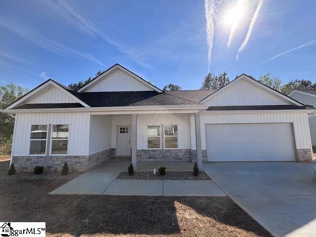 550 Vault Way, Roebuck, SC 29376 - view of front of home with an attached garage, concrete driveway, a porch, and stone siding