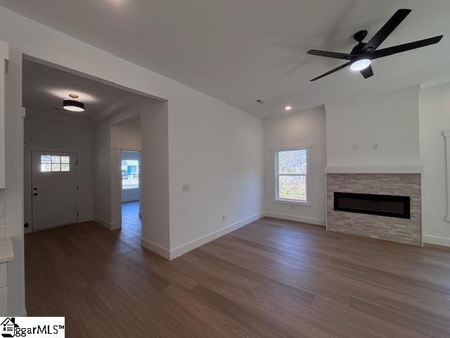 550 Vault Way, Roebuck, SC 29376 - unfurnished living room with a fireplace, baseboards, a wealth of natural light, and wood finished floors