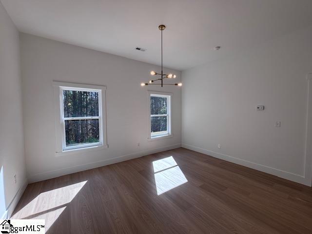 550 Vault Way, Roebuck, SC 29376 - unfurnished room with baseboards, wood finished floors, and a chandelier