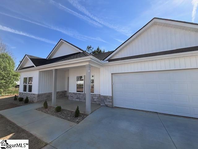 550 Vault Way, Roebuck, SC 29376 - view of front of property with a porch, an attached garage, driveway, and stone siding