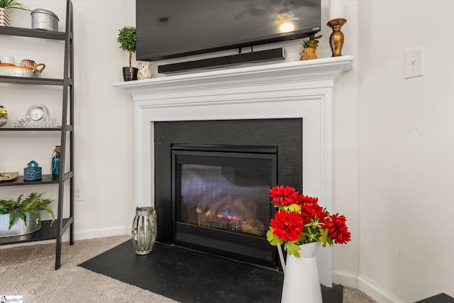 interior details with a fireplace with flush hearth, baseboards, and carpet flooring
