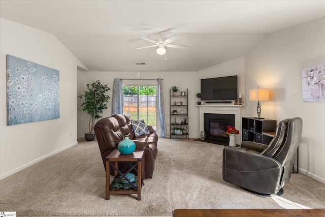 carpeted living area featuring baseboards, a ceiling fan, a fireplace with flush hearth, and vaulted ceiling