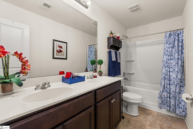 bathroom with double vanity, a sink, shower / tub combo with curtain, and toilet